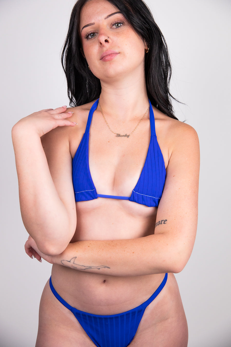 Woman wearing a blue bikini against a plain background